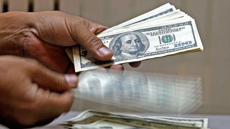 Imagen ilustrativa de un empleado de casa de cambio contando dólares estadounidenses el 22 de febrero de 2005. (LUIS ACOSTA/AFP/Getty Images)