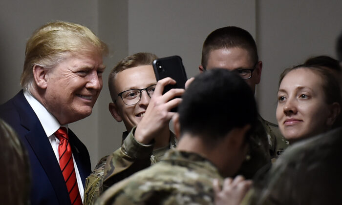El presidente Donald Trump posa para selfies durante una cena de Acción de Gracias con tropas estadounidenses en el Campo Aéreo de Bagram en Afganistán el 28 de noviembre de 2019. (Olivier Douliery/AFP vía Getty Images)