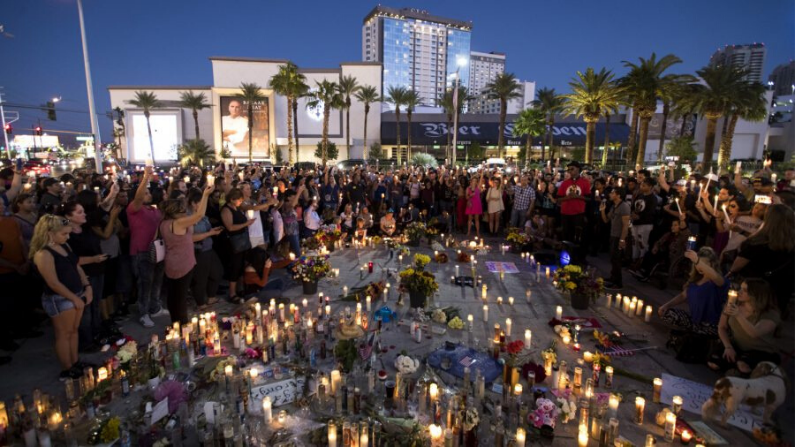 Los asistentes sostienen sus velas en el aire durante un momento de silencio durante una vigilia en Las Vegas, Nevada, el 8 de octubre de 2017. (Getty Images/Drew Angererer)