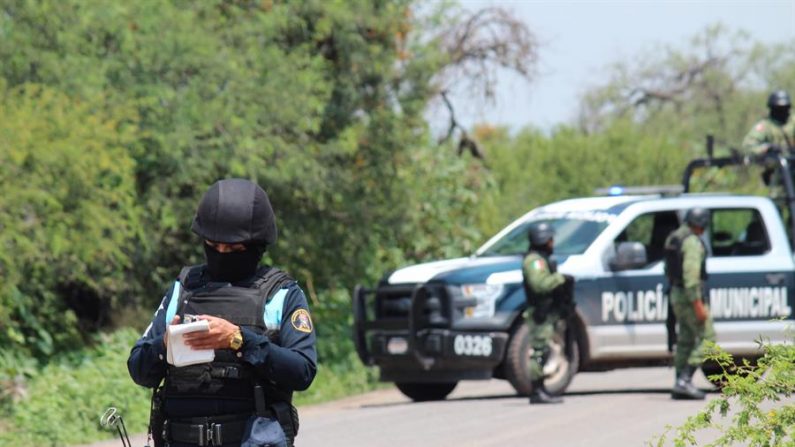 Policías prestan guardia en la zona donde un vehículo policial fue atacado por grupos armados, en Guanajuato, México. (EFE/ STR)