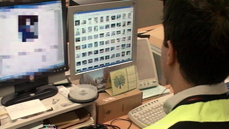 Un miembro de la Policía Nacional de México registra un ordenador en una operación contra la posesión y distribución de pornografía infantil. EFE/Archivo