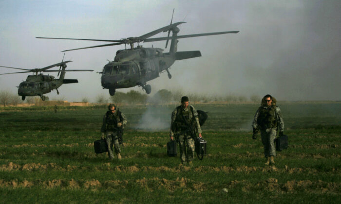Fuerzas especiales del ejército de EE.UU. caminan en un campo mientras los helicópteros Black hawk aterrizan el 24 de febrero de 2010. (Patrick Baz/AFP vía Getty Images)