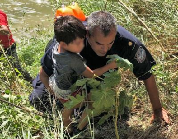 Un oficial de la Oficina de Aduanas y Protección Fronteriza (CBP) ayuda a rescatar a un niño del
Rio Grande, uno de un grupo de personas anclado
en medio del río debido a la fuerte
corrientes, 21 de julio de 2019. Más de 700 oficiales de CBP fueron
desplegado temporalmente en la frontera suroeste
en 2019 para aumentar los agentes de la Patrulla Fronteriza que
fueron abrumados por el volumen de ilegales
cruzando la frontera. (Foto CBP)
