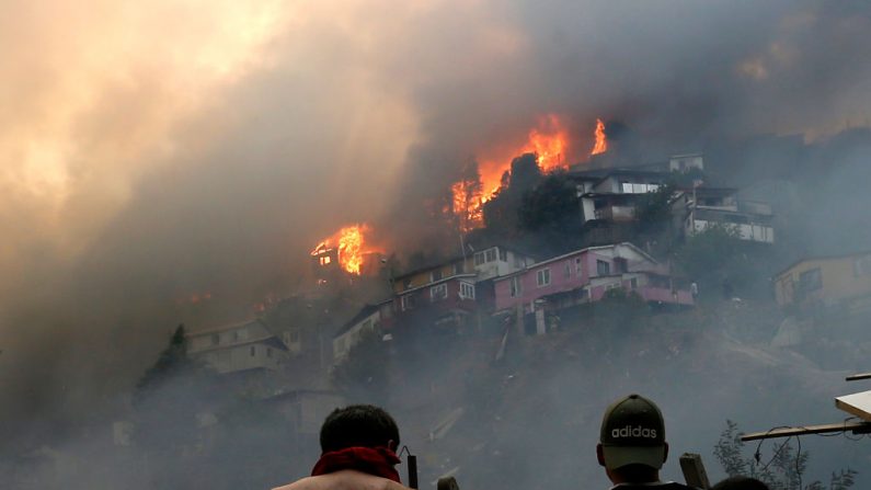 Homens olham para casas em chamas durante um incêndio florestal na Rocuant Hill, em Valparaíso, no Chile, em 24 de dezembro de 2019 (RAUL ZAMORA / ATON CHILE / AFP através da Getty Images)