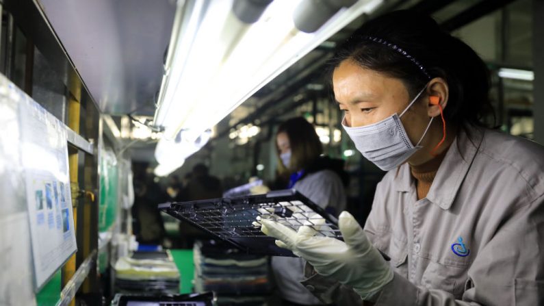 Trabalhadores verificam partes de laptops em uma fábrica no Parque Industrial Automotivo de Hangyong, na cidade de Lu'an, província de Anhui, em 19 de novembro de 2018 (STR / AFP via Getty Images)