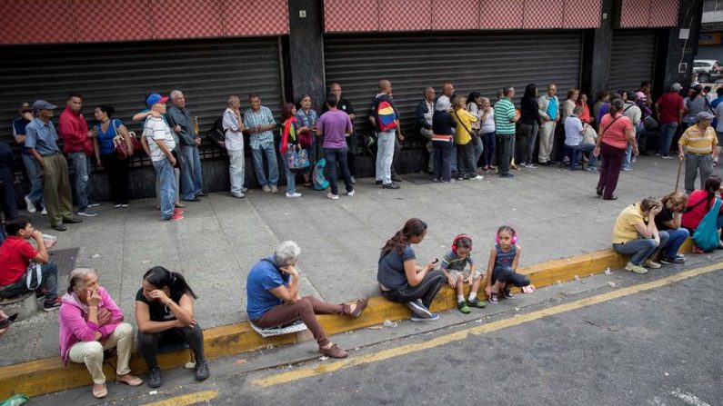 Personas realizan una fila para entrar a un automercado que acepta pagos en Petro, el 28 de diciembre de 2019, en Caracas (Venezuela).  EFE/ Rayner Peña R.
