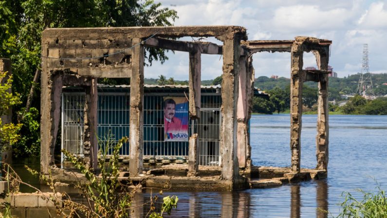 Un cartel de campaña del dictador Nicolás Maduro, se ve en una casa inundada en San Félix, en el estado de Bolívar, sureste de Venezuela, el 10 de agosto de 2018.(William R. Urdaneta / AFP a través de Getty Images)