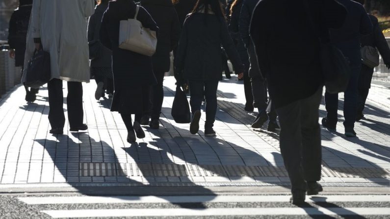 Personas camina por una calle mientras van a trabajar por la mañana en Tokio el 1 de febrero de 2019. (KAZUHIRO NOGI/AFP vía Getty Images)