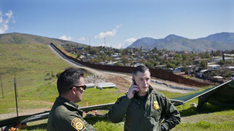 Agentes de la Patrulla Fronteriza se paran a lo largo de la frontera México-Estados Unidos el 22 de febrero de 2019 en Otay Mesa, California. (Foto de Sandy Huffaker/Getty Images)