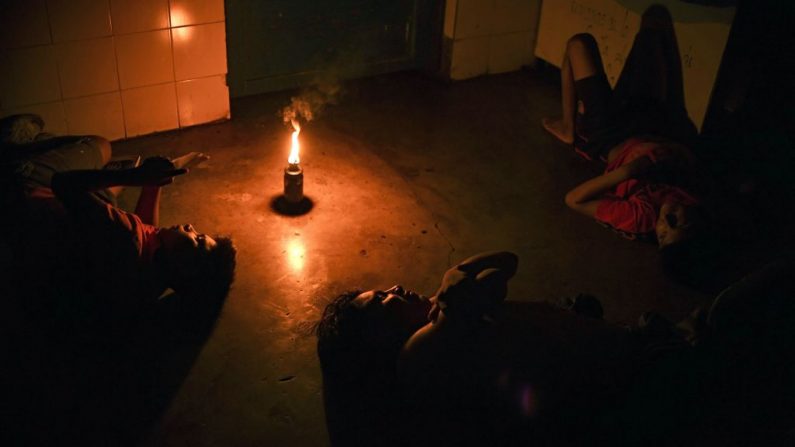 Los ciudadanos de Yukpa permanecen junto a una antorcha durante un apagón en la misión de Los Ángeles del Tukuko, cerca de Machiques, estado de Zulia, Venezuela, el 11 de junio de 2019. (YURI CORTEZ/AFP/Getty Images)