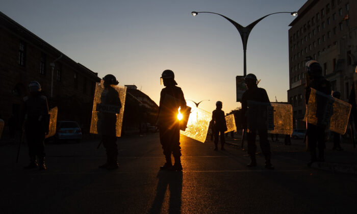 La policía antidisturbios bloquea la entrada a la Corte de Magistrados en Bulawayo, Zimbabwe, el 19 de agosto de 2019. Casi dos años después de que el presidente Emmerson Mnangagwa tomara el poder, el país africano se enfrenta a una inflación creciente, un aumento de la pobreza y una grave escasez de agua. (Tafadzwa Ufumeli/Getty Images)
