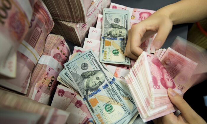 Un empleado del banco chino cuenta billetes de 100 yuanes y billetes de dólares en un mostrador bancario en Nantong, en la provincia oriental china de Jiangsu, el 6 de agosto de 2019. (STR/AFP/Getty Images)