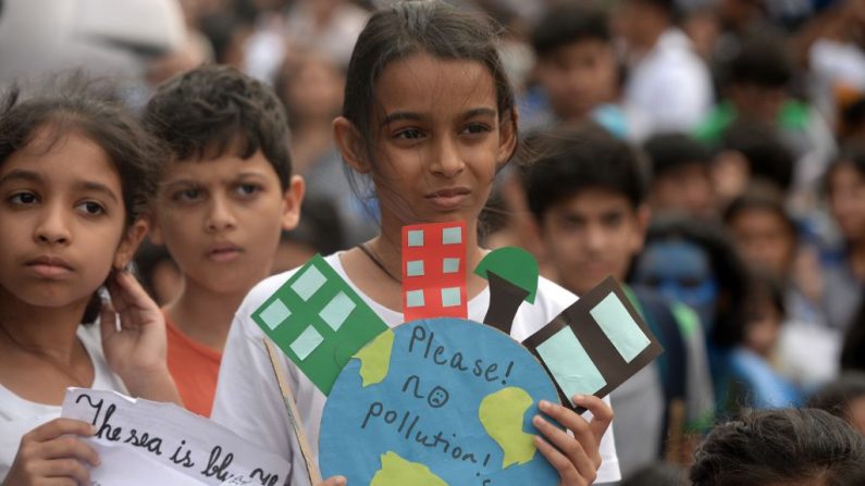 Niñas de escuela sostienen pancartas mientras participan en una huelga climática para protestar contra la inacción de los gobiernos hacia el colapso del clima y la contaminación ambiental en Mumbai el 27 de septiembre de 2019  (PUNIT PARANJPE/AFP vía Getty Images)
