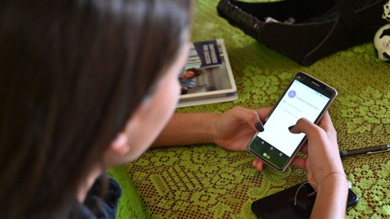 Una mujer revisa su teléfono móvil, el 22 de septiembre de 2019 - foto de archivo (LUIS ROBAYO/AFP vía Getty Images)