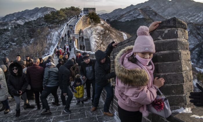 Los turistas luchan por trepar contra el viento en una sección helada de la Gran Muralla en Badaling en Beijing, China, el 30 de noviembre de 2019. (Kevin Frayer / Getty Images) 