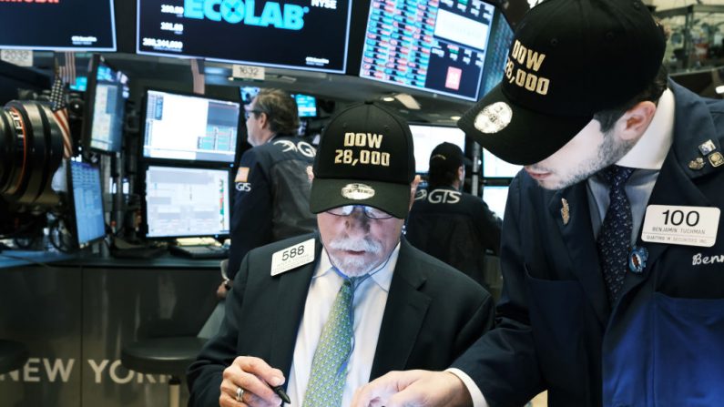 Corredores usan sombreros "DOW 28,000" en el piso de la Bolsa de Nueva York (NYSE) en la ciudad de Nueva York el 15 de noviembre de 2019. (Spencer Platt / Getty Images)