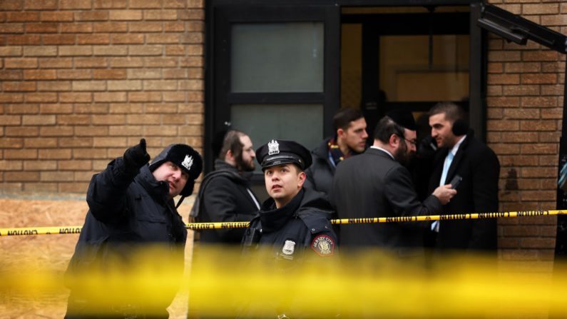 Los oficiales de policía miran los agujeros de bala en las ventanas de una escuela al otro lado de la calle del supermercado JC Kosher el 11 de diciembre de 2019 en Jersey City, Nueva Jersey. (Rick Loomis / Getty Images) 