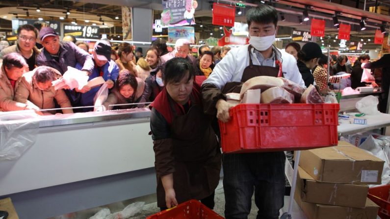 Esta foto, tomada el 19 de diciembre de 2019, muestra a personas tratando de comprar carne de cerdo con descuento en un supermercado recién inaugurado en Binzhou, en la oriental provincia china de Shandong. -  Los precios de la carne de cerdo en China se han duplicado este año tras el brote de peste porcina africana.(STR/AFP vía Getty Images)