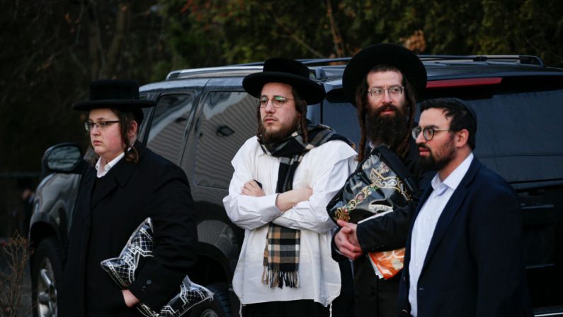 Miembros de la comunidad judía se reúnen frente a la casa del rabino Chaim Rottenbergin en Monsey, Nueva York, el 29 de diciembre de 2019, luego de un ataque con machete en la casa del rabino durante el festival judío de Jánuca en Monsey, Nueva York. (KENA BETANCUR/AFP via Getty Images)
