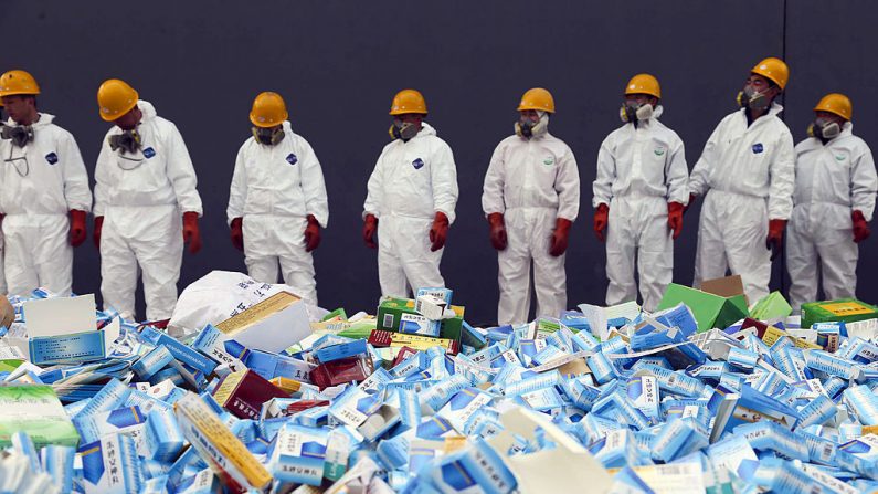 Esta fotografía tomada el 14 de marzo de 2013 muestra a los trabajadores de salud que se preparan para destruir los medicamentos falsos incautados en Beijing en esos últimos meses. (STR/AFP/Getty Images)