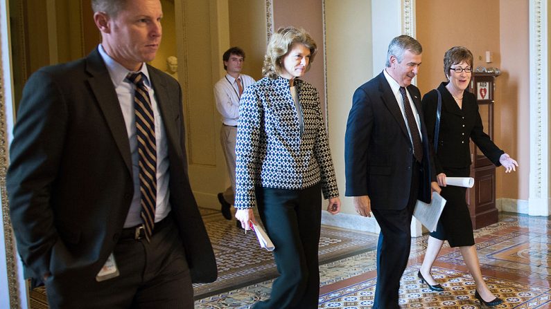 La senadora estadounidense Susan Collins (Der.), R-Maine, camina con Mike Johanns (2º-Der.), R-Nebraska, y la senadora estadounidense Lisa Murkowski (2º-Izq.), R-Alaska, al llegar a una reunión con el líder de la minoría del Senado en el Capitolio en Washington, DC, el 14 de octubre de 2013. (JIM WATSON/AFP a través de Getty Images)
