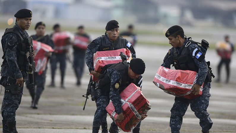 Policías llevan paquetes de cocaína incautada durante una operación antidrogas en Izabal, al noroeste de la ciudad de Guatemala, el 23 de octubre de 2013. (JOHAN ORDONEZ/AFP/Getty Images)