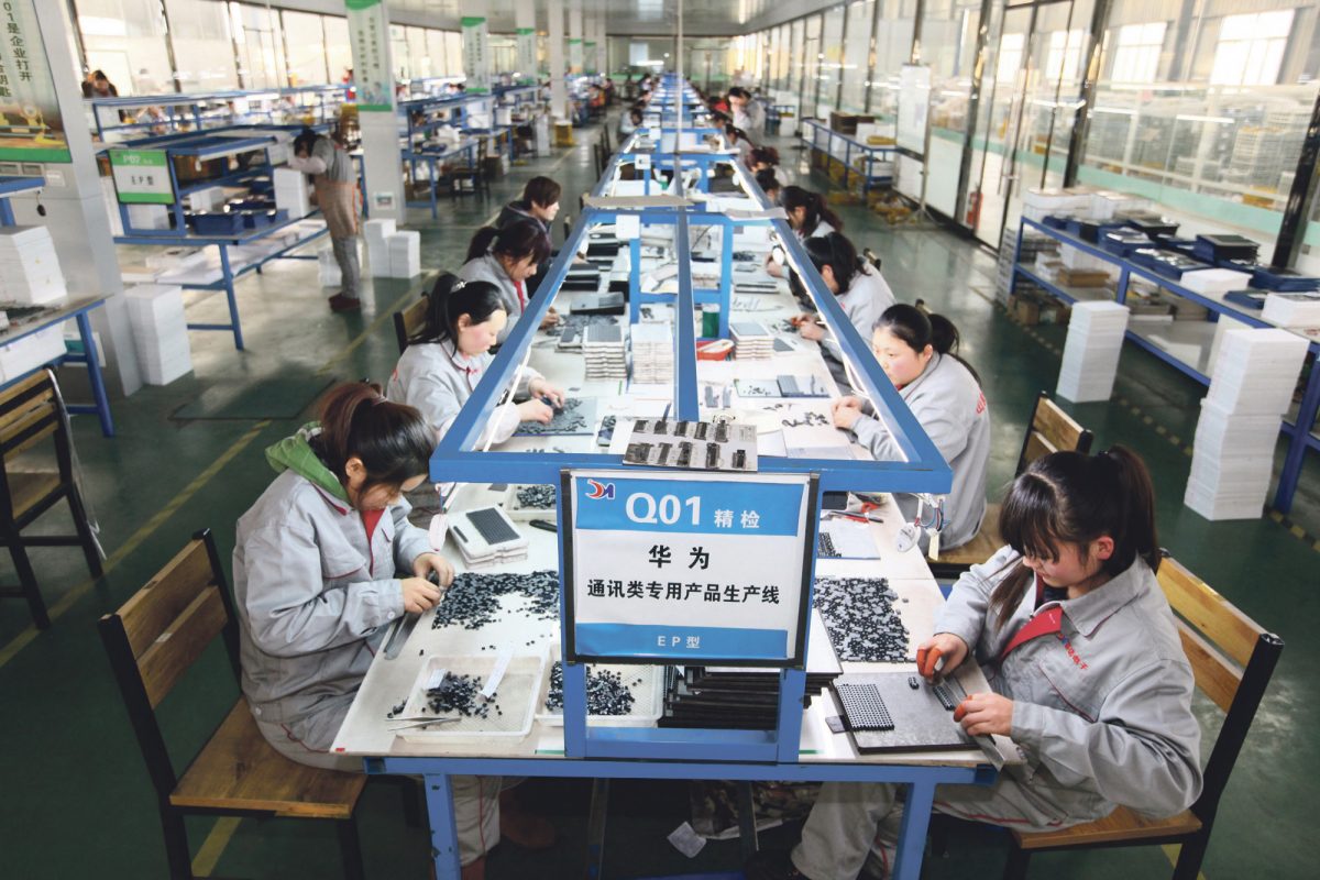 Trabajadores clasifican piezas en una empresa de electrónica en Tengzhou