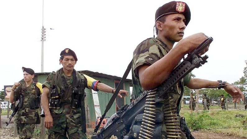 Guerrilleros de las Fuerzas Armadas Revolucionarias de Colombia (FARC) custodian la ubicación de las conversaciones entre Manuel Marulanda, jefe rebelde marxista de las FARC y el presidente colombiano Andrés Pastrana en Los Pozos (Caqueta), 750 km (466 millas) al sur de Bogotá, el 9 de febrero de 2001. (LUIS ACOSTA/AFP vía Getty Images)