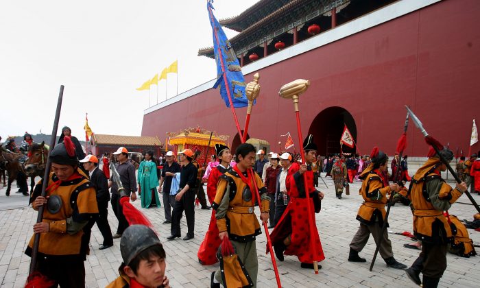 Extras vestidos con trajes en forma de la Dinastía Qing, descansan en un lugar de rodaje de la Base de Locaciones de Cine y Televisión Hengdian el 12 de mayo de 2006 en Dongyang de la Provincia de Zhejiang, China. (Fotos de China / Getty Images)