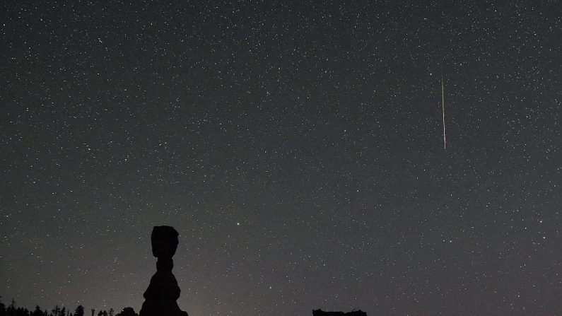 Un meteorito de las Perseidas atraviesa el cielo sobre los hoodoos llamado Thor's Hammer (L) y Three Sisters (R) a principios del 13 de agosto de 2016 en el Parque Nacional Bryce Canyon, Utah. La exhibición anual, conocida como la lluvia de las Perseidas porque los meteoritos parecen irradiar desde la constelación de Perseo en el cielo del noreste, es el resultado de la órbita de la Tierra que atraviesa los escombros del cometa Swift-Tuttle. (Foto de Ethan Miller / Getty Images)