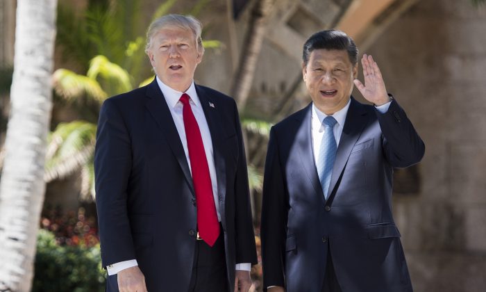 El líder chino Xi Jinping (Der.) saluda a la prensa mientras camina con el presidente de Estados Unidos Donald Trump en la finca Mar-a-Lago en West Palm Beach, Florida, el 7 de abril de 2017. (Jim Watson/AFP/Getty Images)
