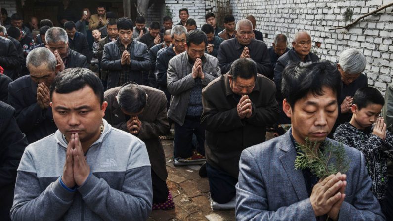Fieles católicos chinos se arrodillan y rezan en la Misa del Domingo de Ramos durante la Semana Santa de Pascua, en una iglesia "clandestina" o "no oficial", cerca de Shijiazhuang, provincia de Hebei, China, el 9 de abril de 2017. (Kevin Frayer/Getty Images)
