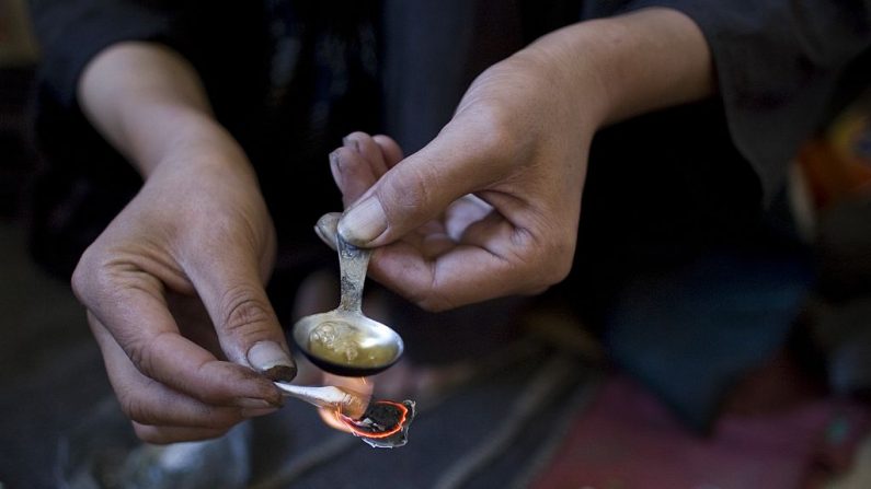 Un adicto a la heroína cocina la mezcla de para inyectarse. (Paula Bronstein/Getty Images)
