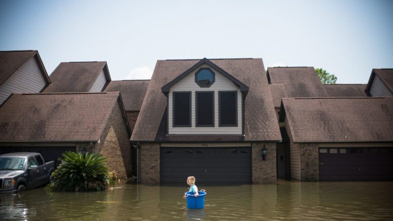 Jenna Fountain lleva un cubeta por Regency Drive para tratar de recuperar artículos de su casa inundada luego del huracán Harvey, en Port Arthur, Texas (EE.UU.), el 1 de septiembre de 2017. (EMILY KASK/AFP a través de Getty Images)