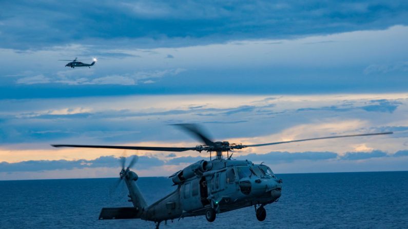 En una imagen de archivo de tareas de rescate de la Marina de los EE. UU., dos helicópteros MH-60S Sea Hawk unidos al Helicopter Sea Combat Squadron (HSC) 22 aterrizan en la cubierta de vuelo del buque de asalto anfibio USS Wasp el 28 de septiembre de 2017. (Seaman Taylor King / US Navy a través de Getty Images))