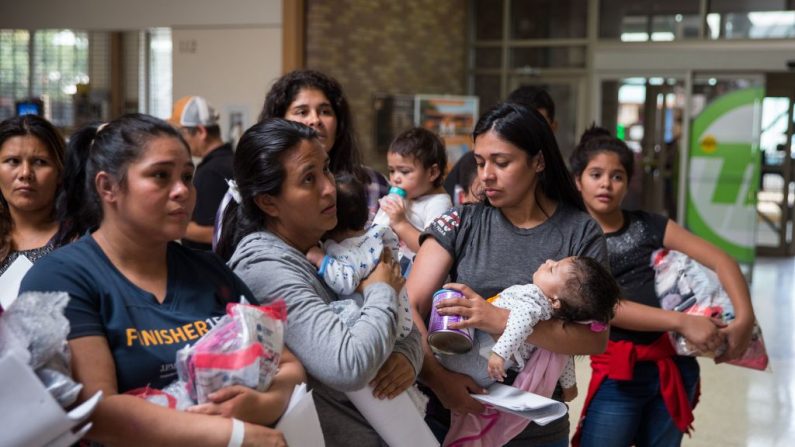 Los inmigrantes esperan para dirigirse a un centro de ayuda de Catholic Charities el 17 de junio de 2018 en McAllen, Texas. (LOREN ELLIOTT/AFP/Getty Images)