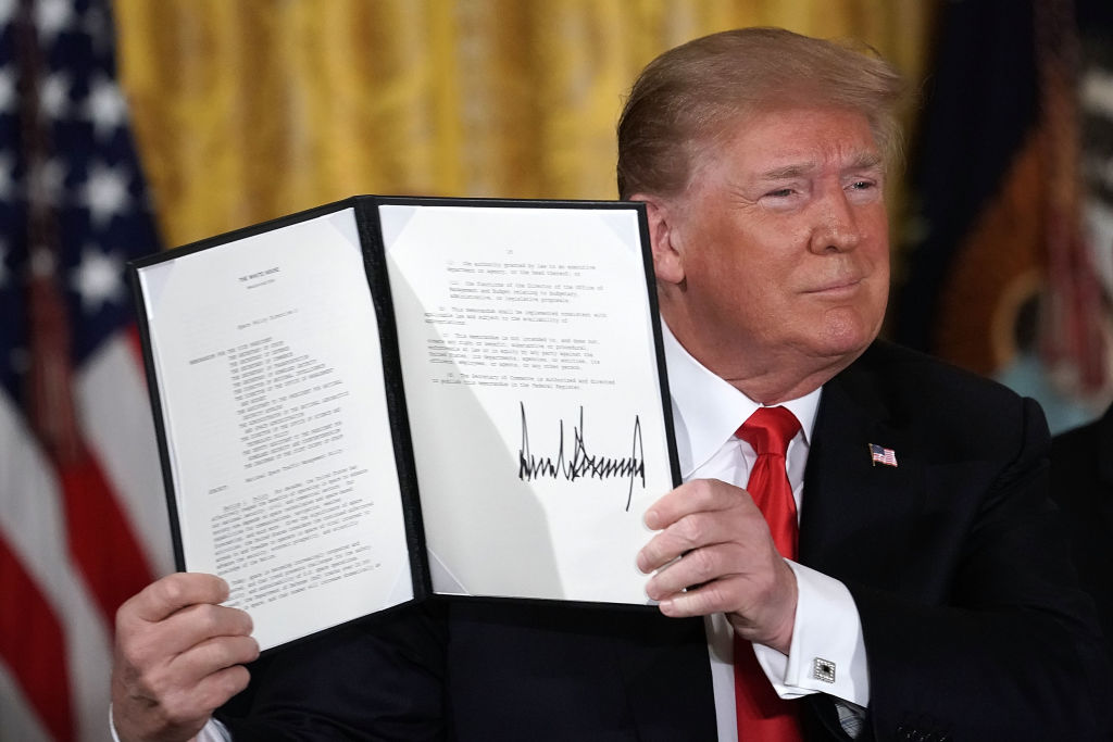 El Presidente de Estados Unidos, Donald Trump, sostiene una orden ejecutiva que firmó durante una reunión del Consejo Nacional Espacial en la Sala Este de la Casa Blanca el 18 de junio de 2018 en Washington