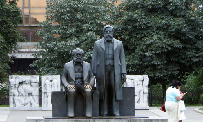 Uma estátua de Karl Marx e Friedrich Engels, os principais arquitetos do comunismo, em frente ao Palácio da República em Berlim, Alemanha  (John MacDougall / AFP / Getty Images)