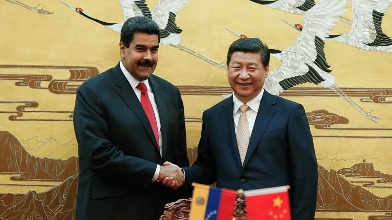 O líder comunista da China, Xi Jinping (direita) e o presidente chavista da Venezuela, Nicolás Maduro (esquerda), apertam as mãos durante uma cerimônia de assinatura entre os dois países no Grande Salão do Povo em Pequim, em 22 de setembro de 2013. (LINTAO ZHANG / AFP / Getty Images)