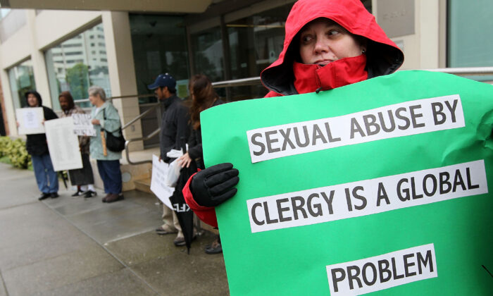 Una manifestante sostiene un letrero en una manifestación con miembros del grupo SNAP, la Red de Sobrevivientes de los Abusados por Sacerdotes, en el exterior de las oficinas de la Arquidiócesis de San Francisco en San Francisco, California, el 29 de marzo de 2010. (Justin Sullivan/Getty Images)