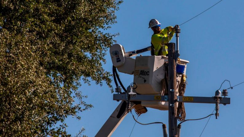 Un contratista de PG&E trabaja en postes de servicios públicos a lo largo de la carretera 128 cerca de Geyserville, California, el 31 de octubre de 2019. (Créditos: PHILIP PACHECO/AFP vía Getty Images)