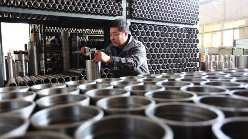 Trabalhador verifica peças de tubos de perfuração em uma fábrica na cidade de Xuanhua, na província norte de Hebei, na China, em 18 de dezembro de 2019 (STR / AFP via Getty Images)