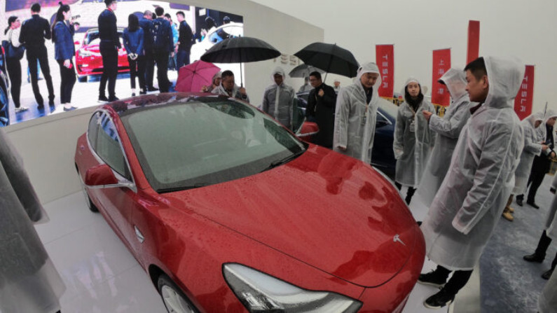  Visitantes admiram um Tesla Model 3 durante cerimônia de inovação para uma fábrica da Tesla em Xangai, China, em 7 de janeiro de 2019 (STR / AFP via Getty Images)
