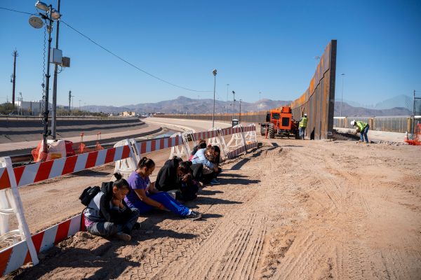 Migrantes salvadoreños esperan a que llegue el transporte tras entregarse a la Patrulla Fronteriza de los EE.UU. junto a un muro fronterizo que se está construyendo en El Paso, Texas, el 19 de marzo de 2019. (Paul Retje/AFP/Getty Images)