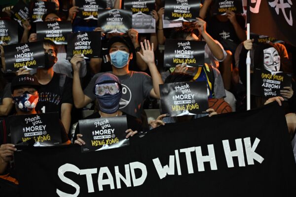 manifestantes gritan consignas mientras sostienen volantes en el patio de recreo Southorn en Hong Kong