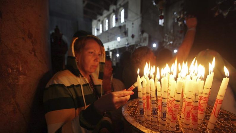 Uma mulher acende velas na igreja da Natividade de Belém, onde a tradição cristã afirma que Jesus de Nazaré nasceu, na Cisjordânia (EFE / Abed Al Hashlamoun / Arquivo)