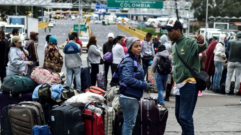 Migrantes venezuelanos esperam do lado de fora do escritório de migração colombiano na Ponte Internacional Rumichaca, na fronteira entre Ipiales, Colômbia e Tulcan, Equador, em 20 de agosto de 2018 (Luis Robayo / AFP / Getty Images)