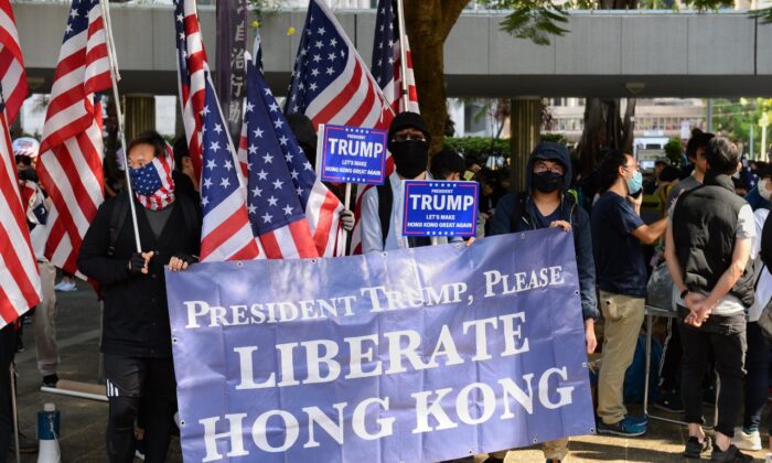 Manifestantes levantan una pancarta gigante y banderas de Estados Unidos en un mitin en el Charter Garden de Hong Kong el 1 de diciembre de 2019. (Sun Pi-lung/La Gran Época)