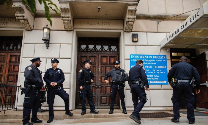 Agentes de la policía de Nueva York hacen guardia en la puerta del Templo de la Unión de Brooklyn en Nueva York, el 2 de noviembre de 2018. La policía determinó que el graffiti antisemita encontrado dentro de una sinagoga de Brooklyn fue garabateado por un antiguo funcionario del ayuntamiento. (Kena Betancur/AFP/Getty Images)