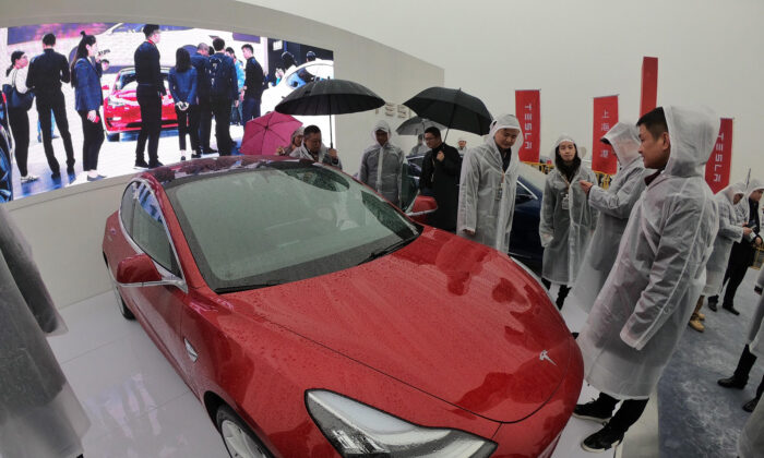 Los invitados miran un Tesla Model 3 durante una ceremonia de innovación para una fábrica de Tesla en Shanghai, China, el 7 de enero de 2019. (STR / AFP a través de Getty Images)